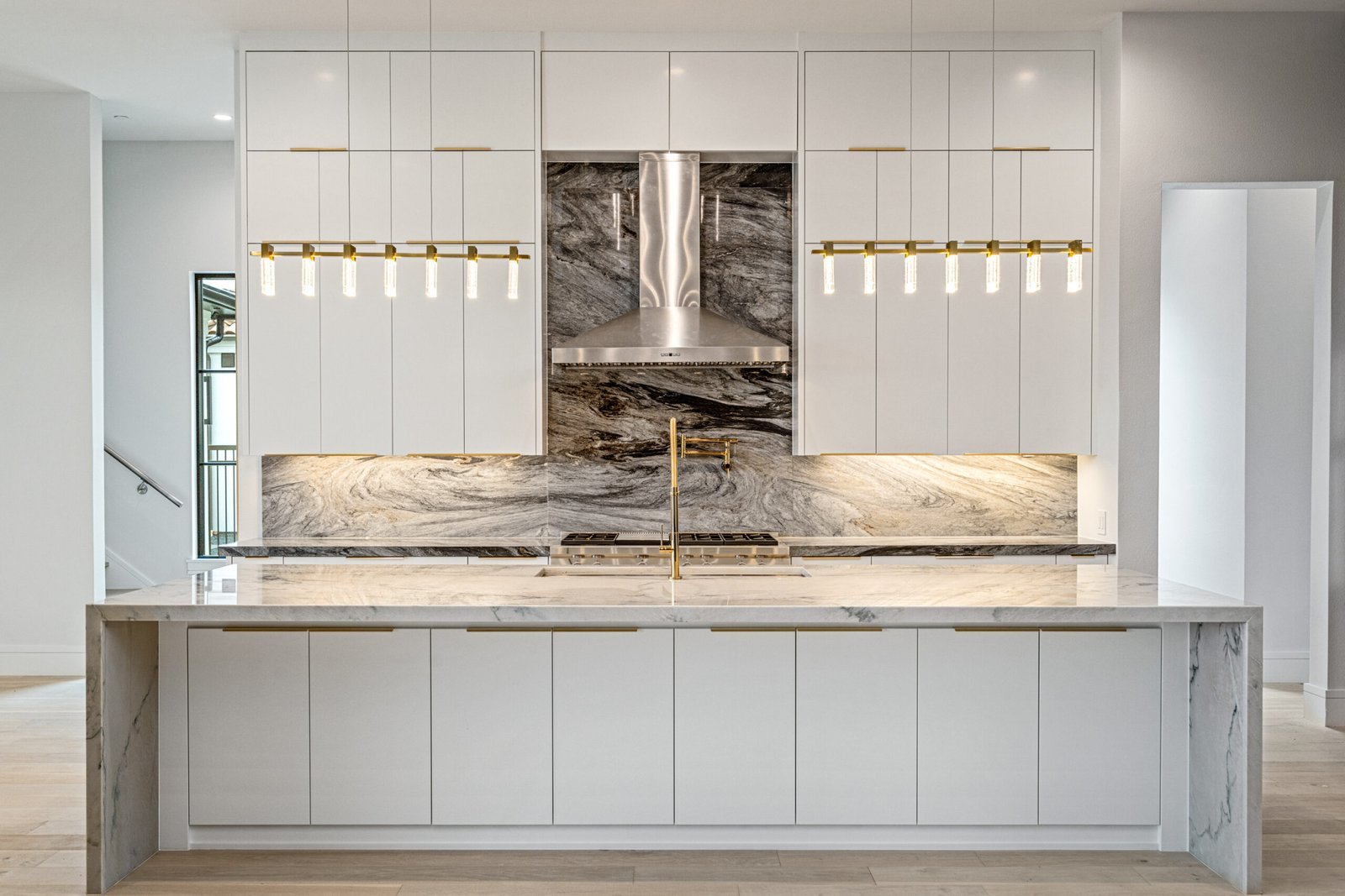 Custom kitchen with marble backsplash and statement lighting at Balfour Court Custom Home