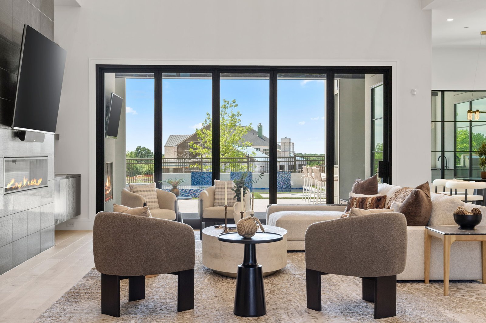 Furnished living room opening to the pool at Balfour Court Custom Home