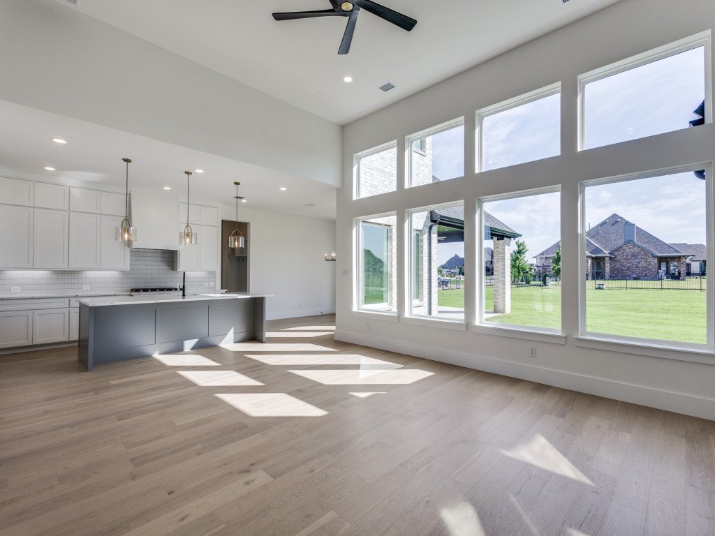 Sunlit great room with a wall of windows and views of the backyard