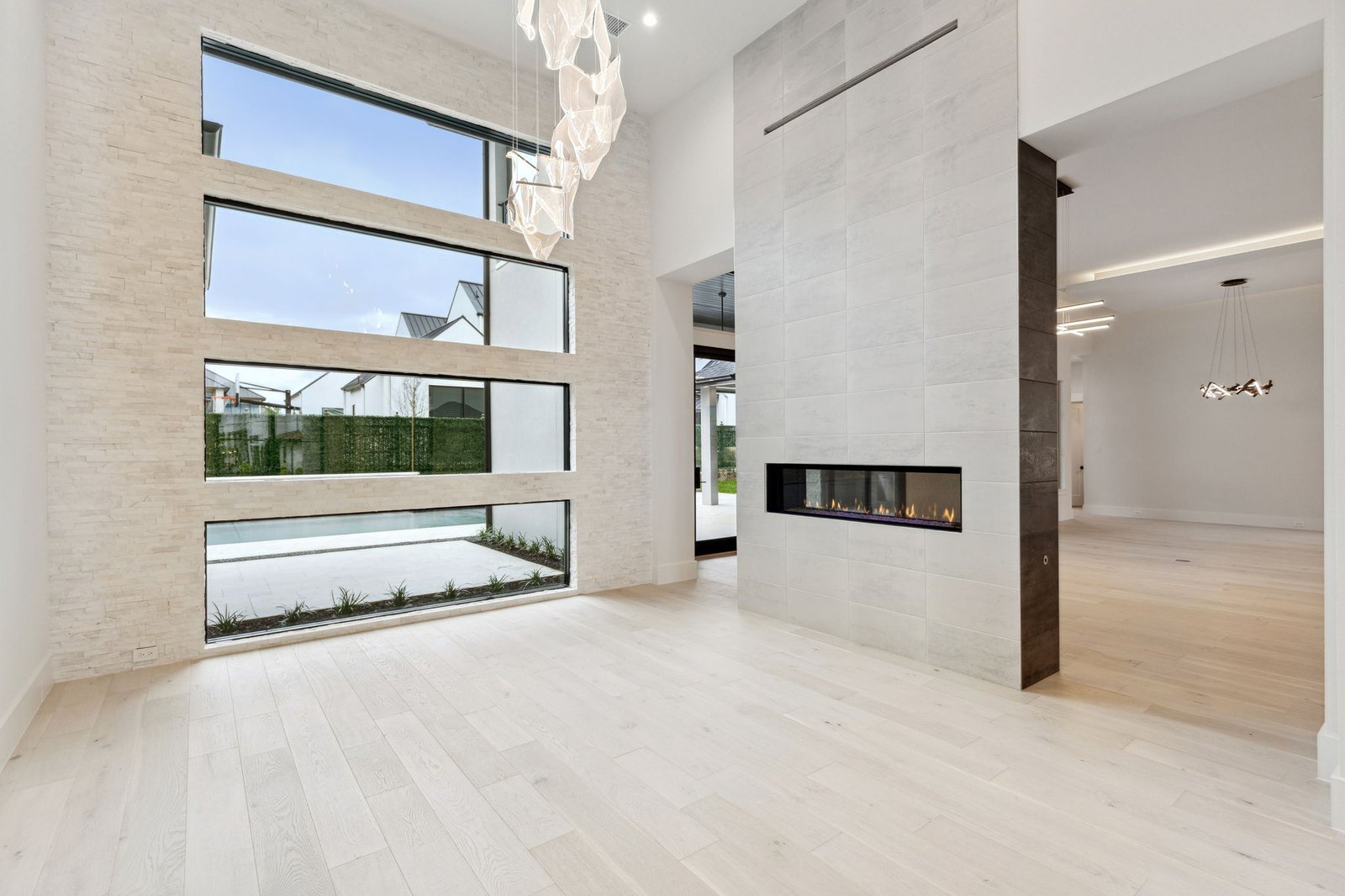 Double-height living room with linear fireplace at Chambord Custom Home I