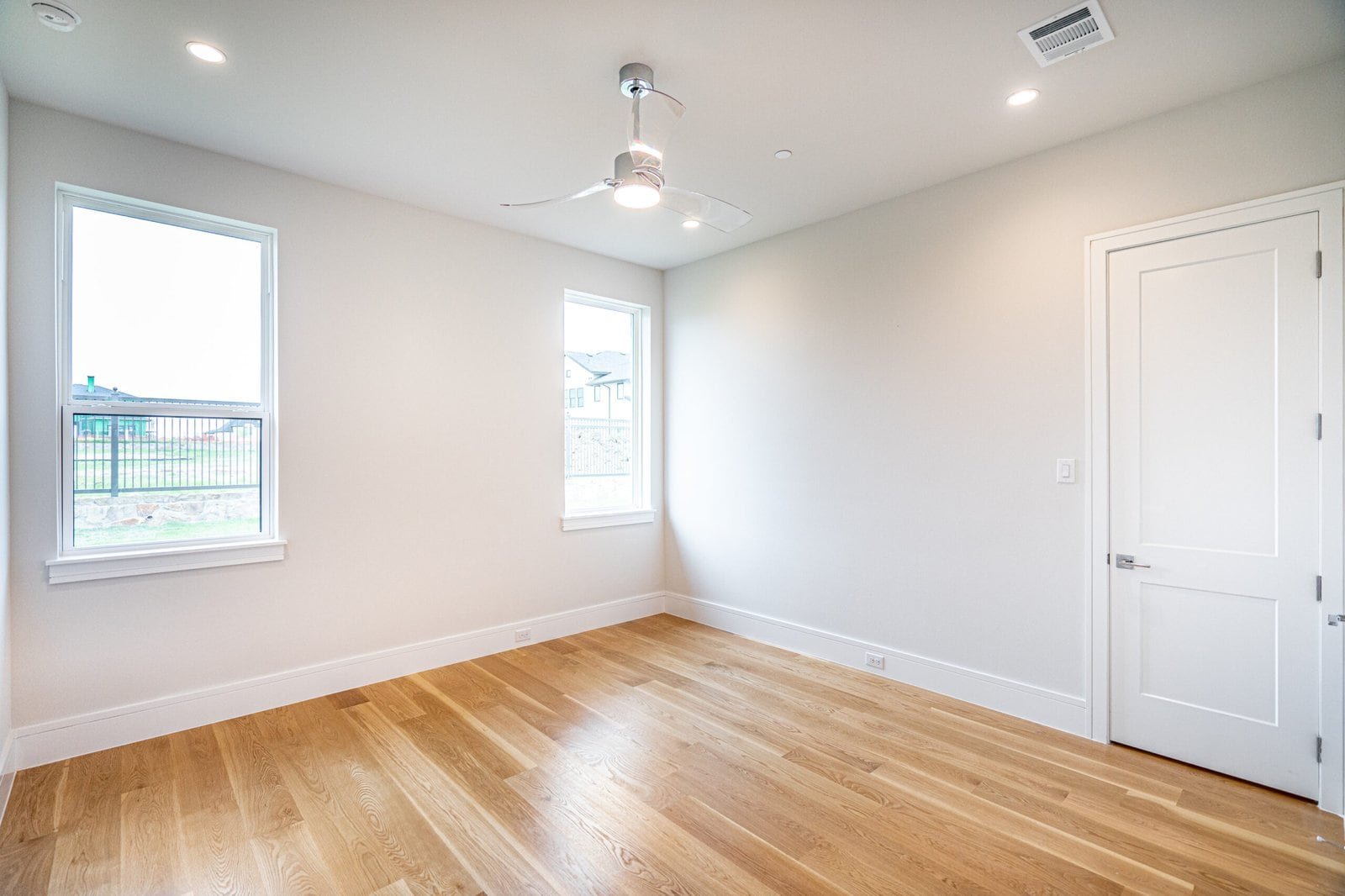 Light-filled bedroom with wood flooring at Chambord Custom Home II