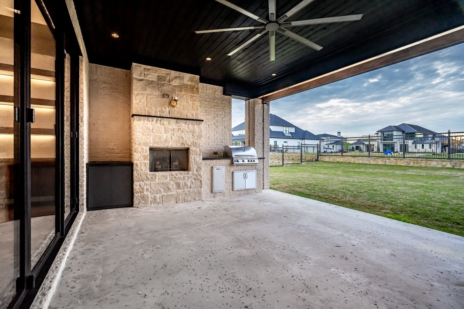 Covered outdoor living area with fireplace at Chambord Custom Home II