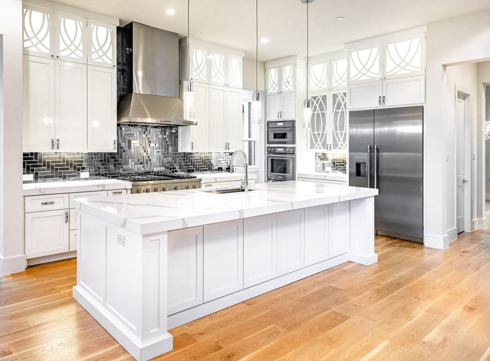 Custom white kitchen with island at Chambord Custom Home II