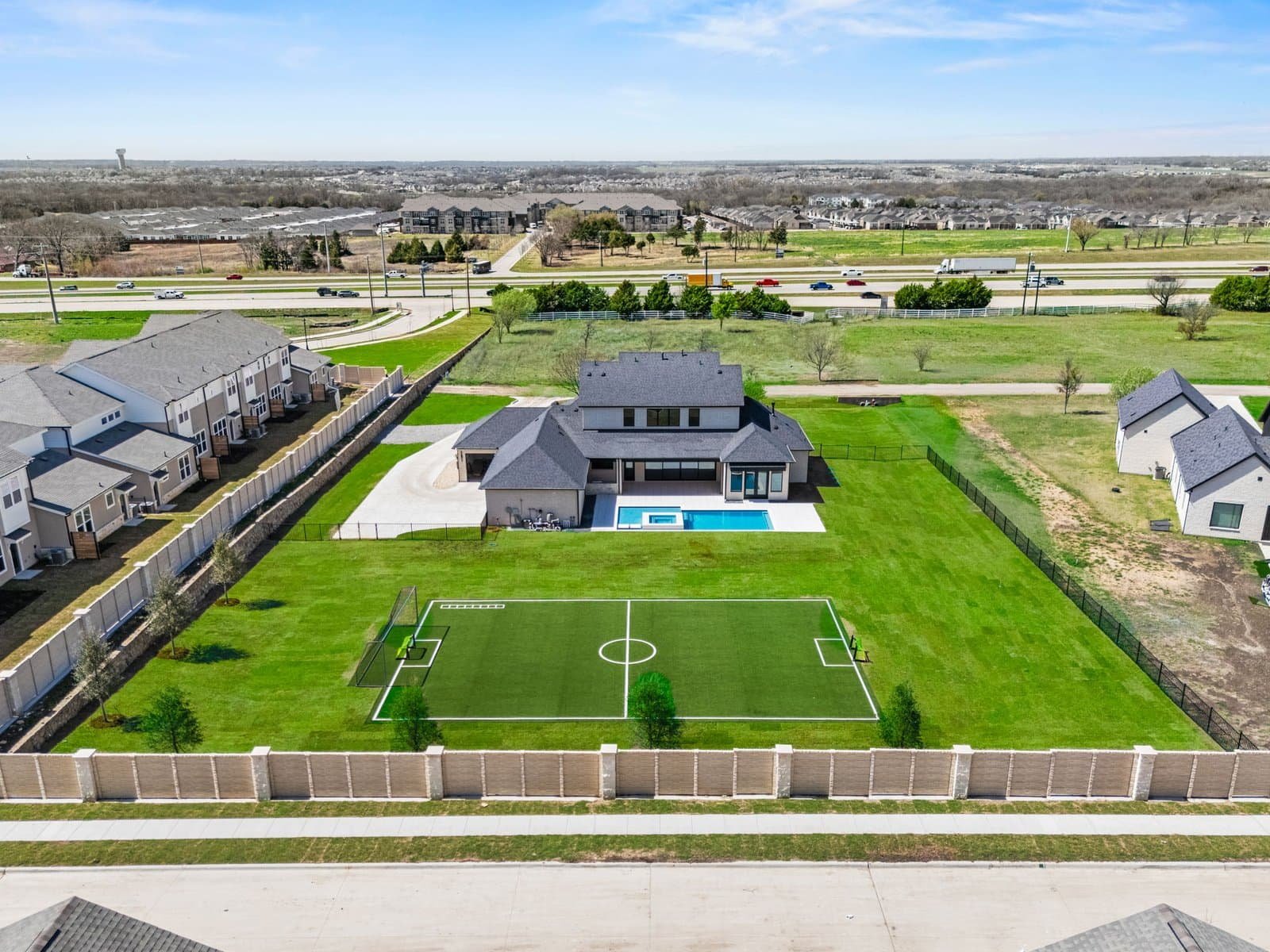 Aerial view of a large Melissa backyard with a swimming pool, lawn and private sport court
