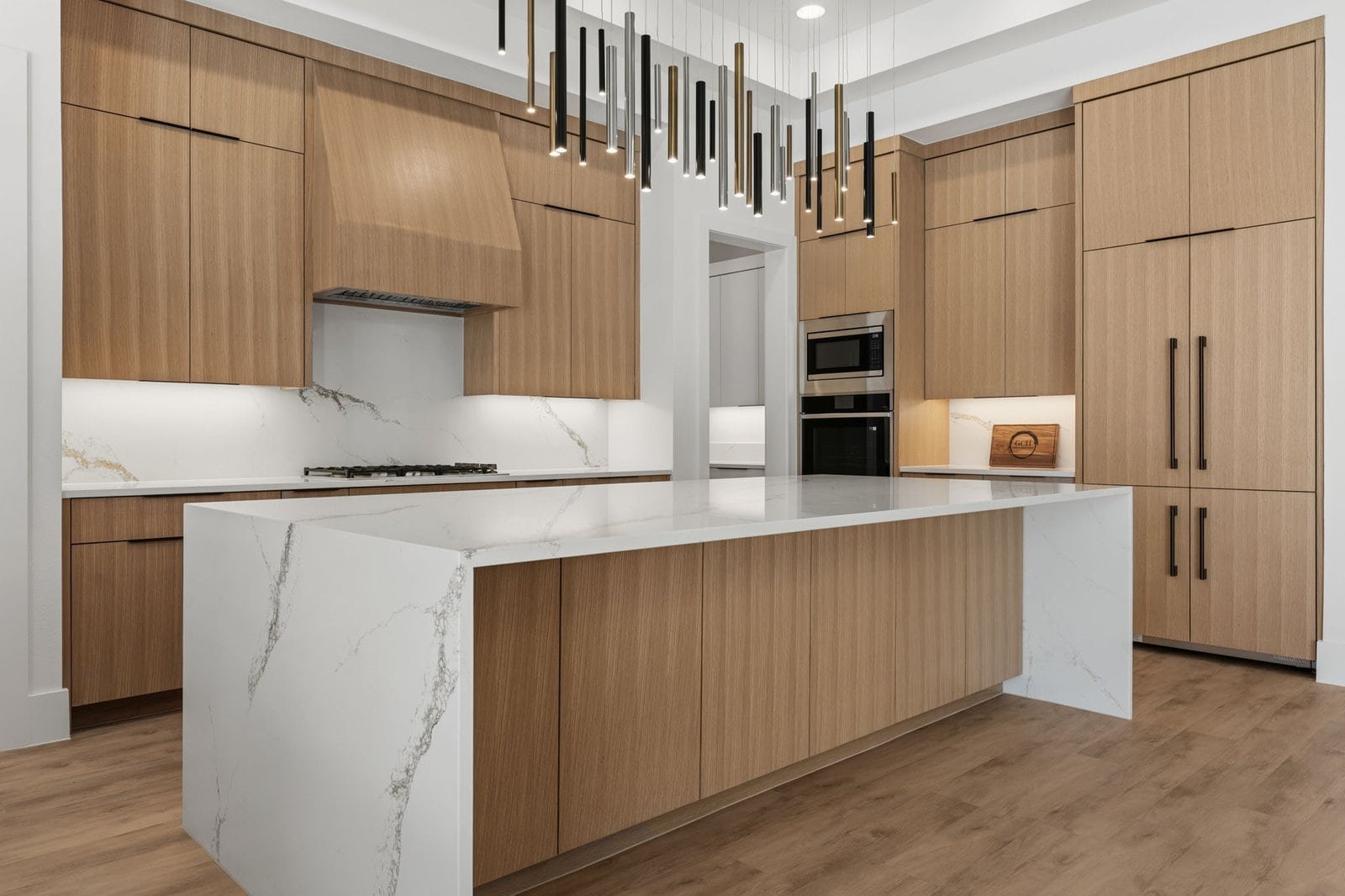 Custom kitchen with waterfall island and designer lighting in Melissa, Texas