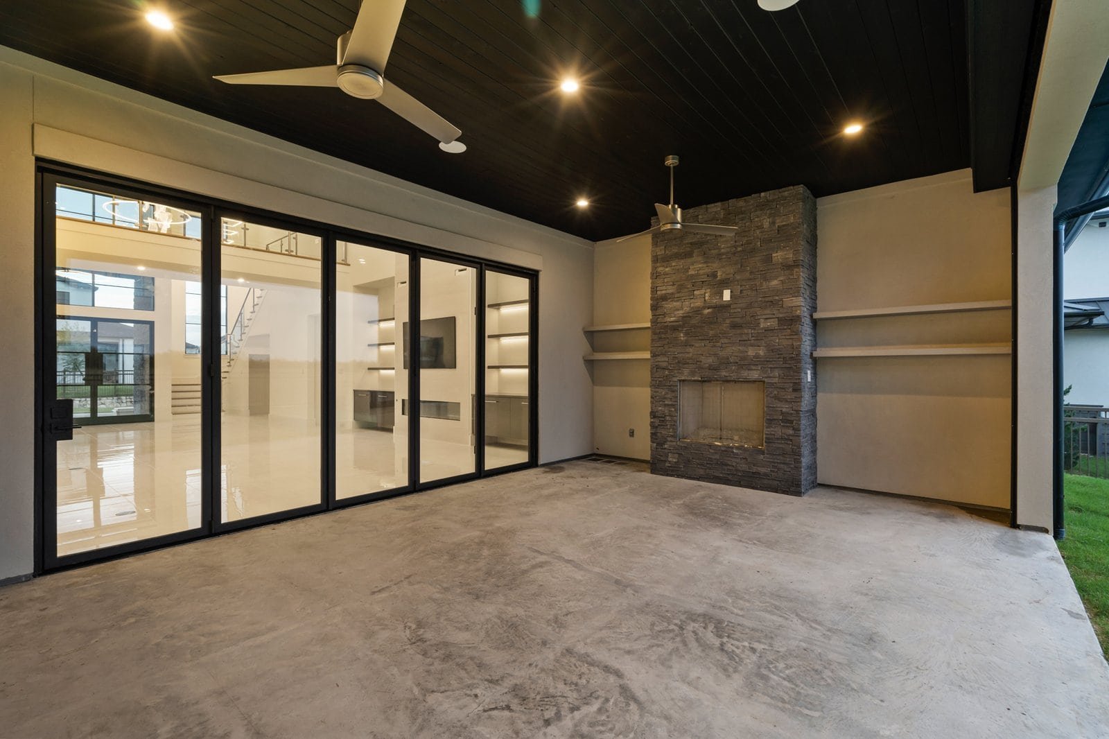 Covered outdoor living area with fireplace at Midwick Custom Home
