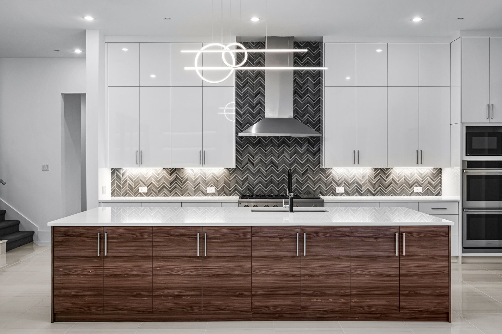 Contemporary kitchen with wood island cabinetry at Midwick Custom Home