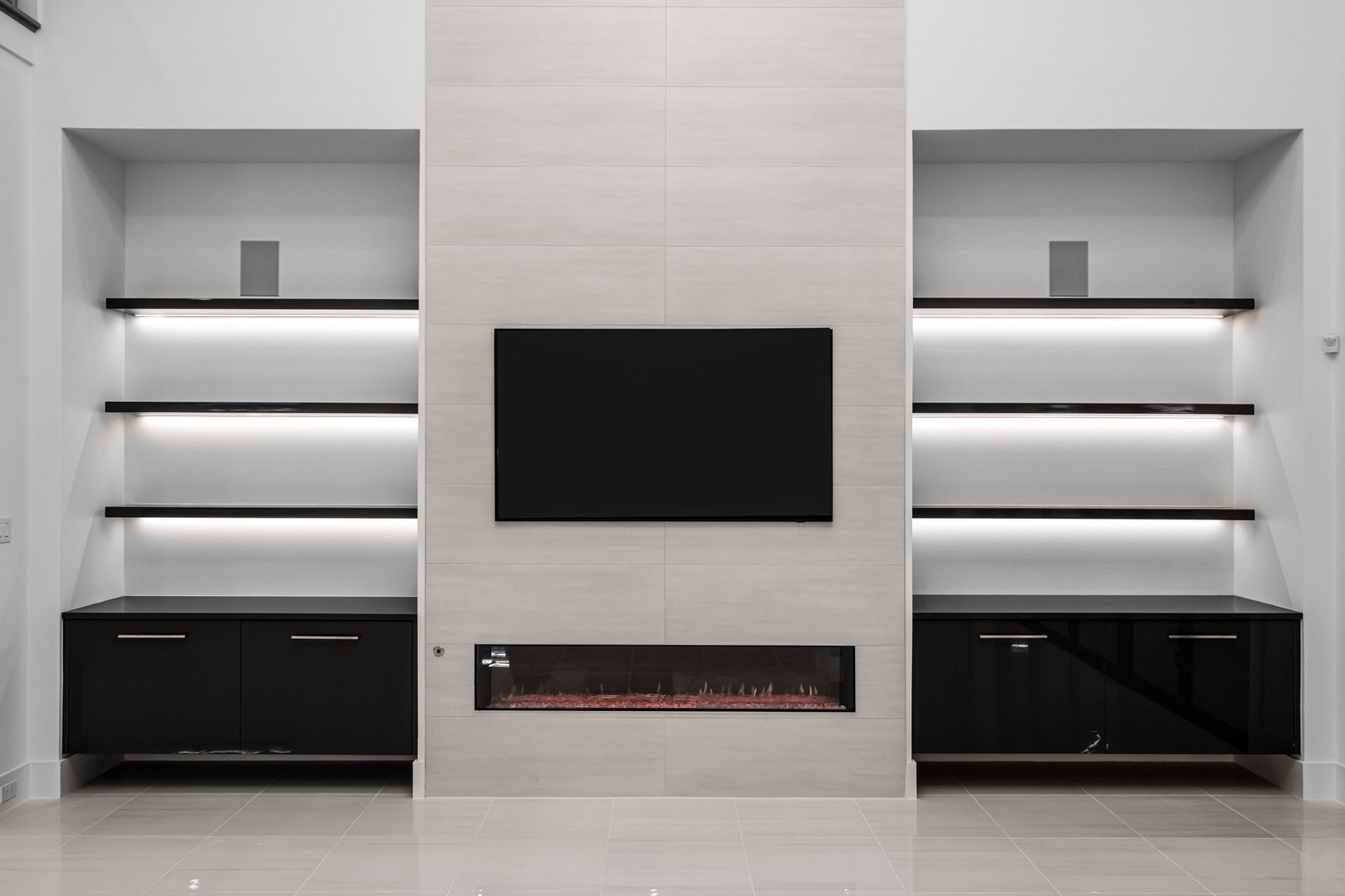 Modern fireplace wall with illuminated built-ins at Midwick Custom Home
